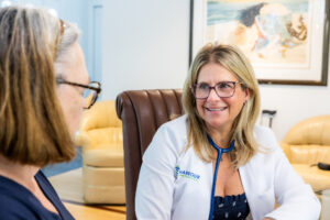 A woman smiles as she discusses a patient's noninvasive facelift near Newport, RI.