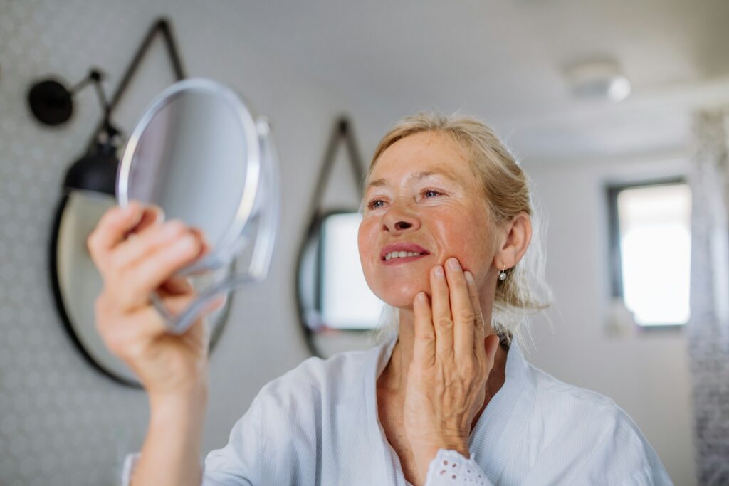 Woman admires results from a skin rejuvenation treatment in Jamestown, RI.